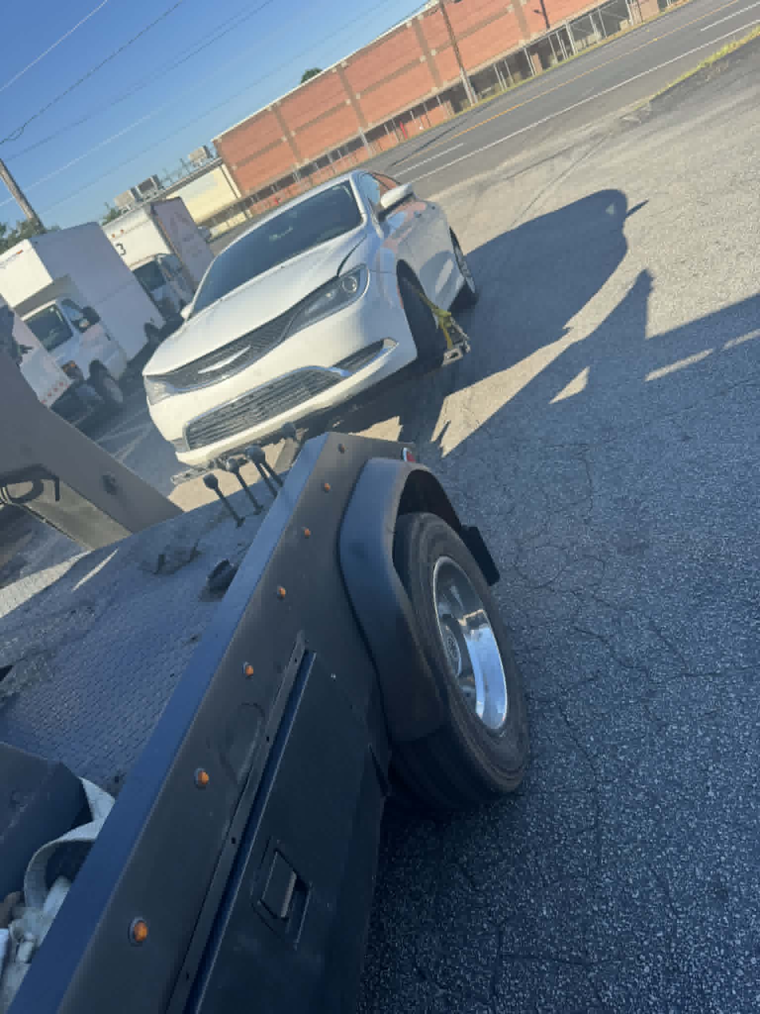 Taylor's Towing flatbed loading a silver sedan in an Upstate SC commercial lot