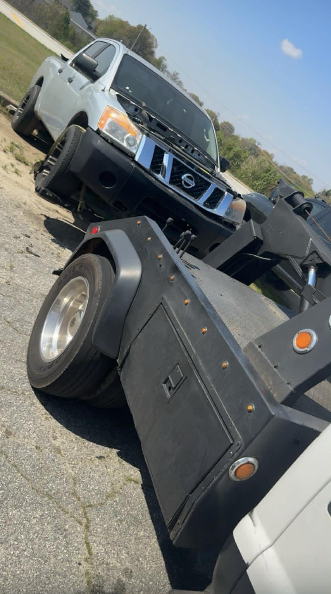 Heavy-duty Taylor's Towing wrecker hauling a silver Nissan Titan pickup
